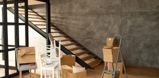 Cómo hacer el cambio de uso de local a vivienda y qué ha cambiado en Madrid Local diáfano con suelo de madera y escalera, convertido en vivienda durante la mudanza