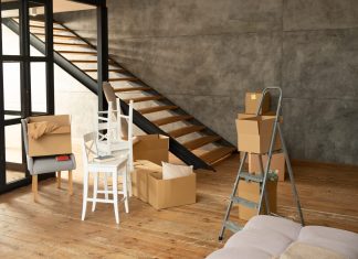 Cómo hacer el cambio de uso de local a vivienda y qué ha cambiado en Madrid Local diáfano con suelo de madera y escalera, convertido en vivienda durante la mudanza