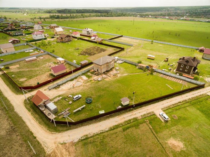 Parcelas vistas desde el aire Vista aérea de parcelas y viviendas unifamiliares en construcción junto a campos de cultivo